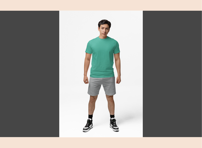 Man wearing a green t-shirt and gray shorts standing against a white background