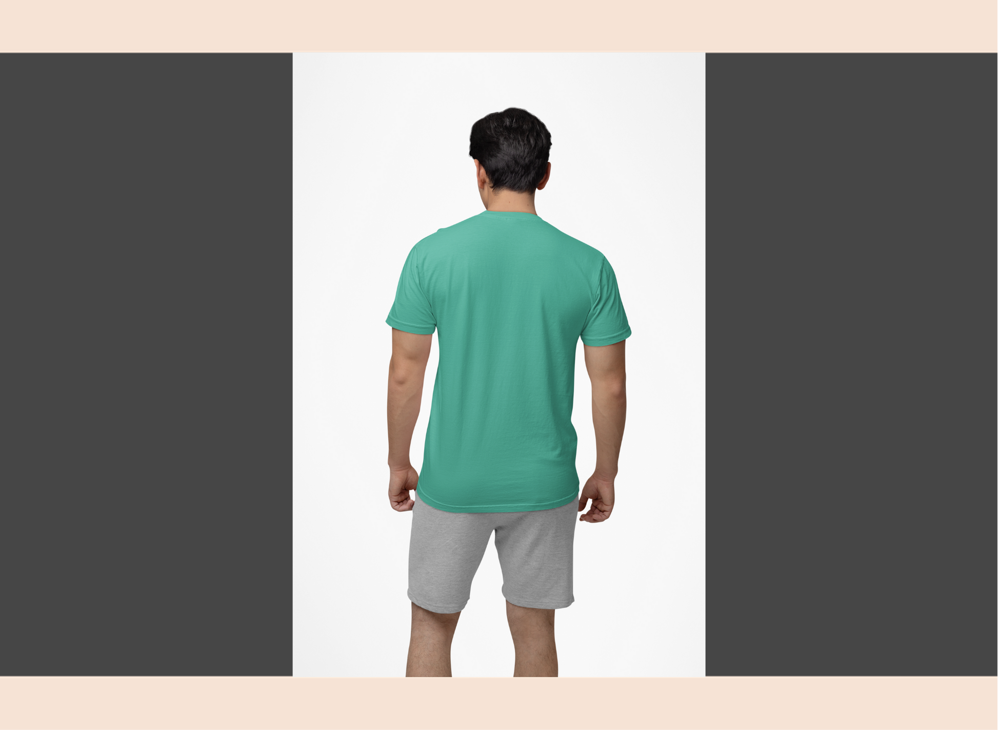 Man wearing a green t-shirt and gray shorts on a plain background