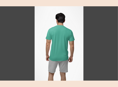 Man wearing a green t-shirt and gray shorts on a plain background
