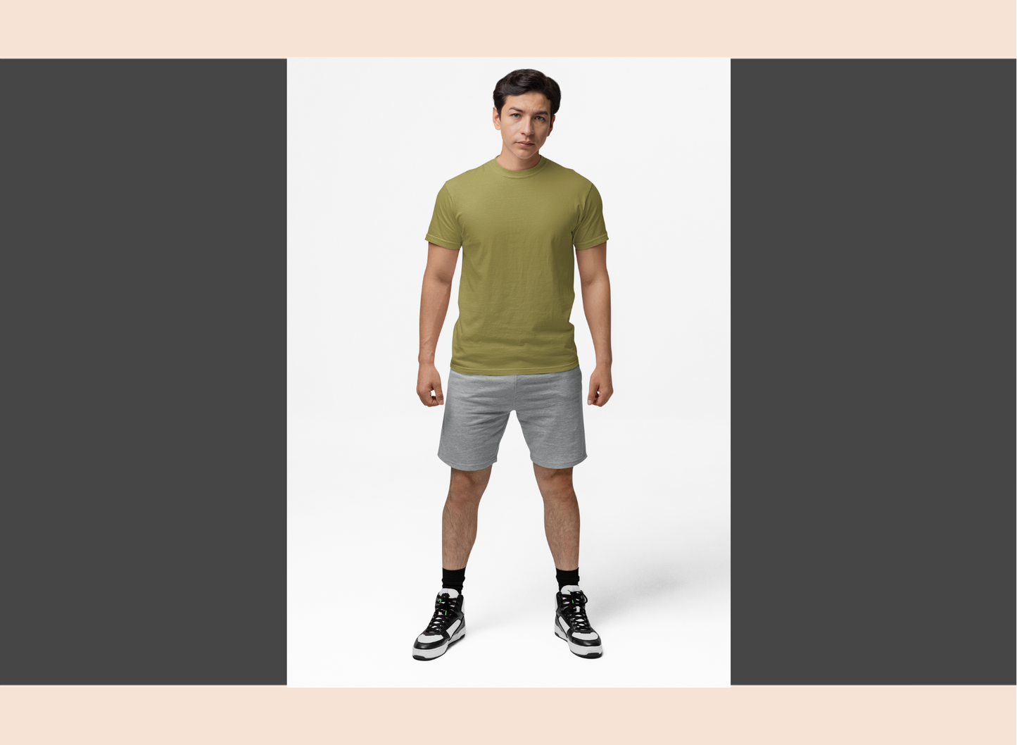 Man wearing a green t-shirt and gray shorts on a white background