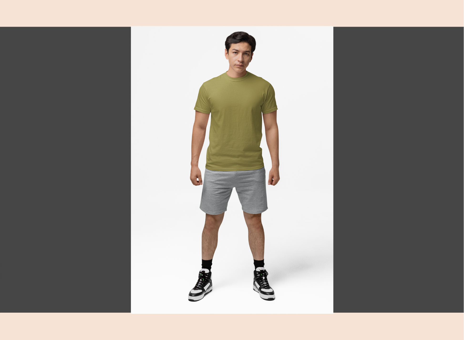 Man wearing a green t-shirt and gray shorts on a white background