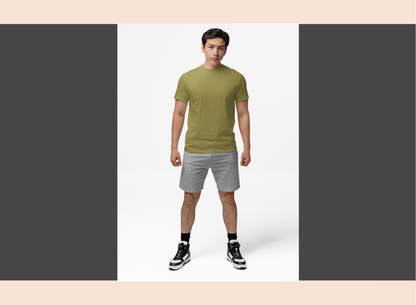 Man wearing a green t-shirt and gray shorts on a white background