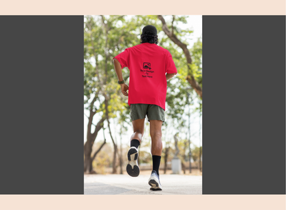 Person running outdoors wearing a red t-shirt with a logo