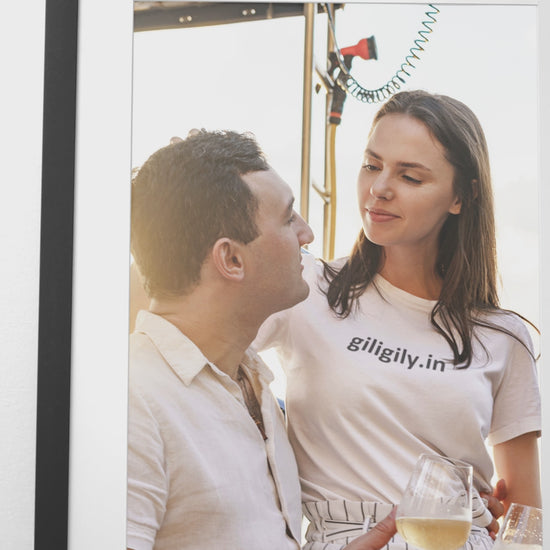Framed photo of a woman in a green top and yellow skirt, with a vase and calendar in the foreground.