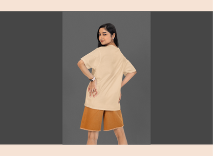 Woman wearing a beige top and brown shorts on a gray background