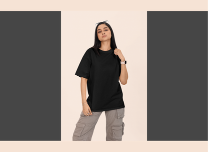 Person wearing a black t-shirt and gray cargo pants on a beige background