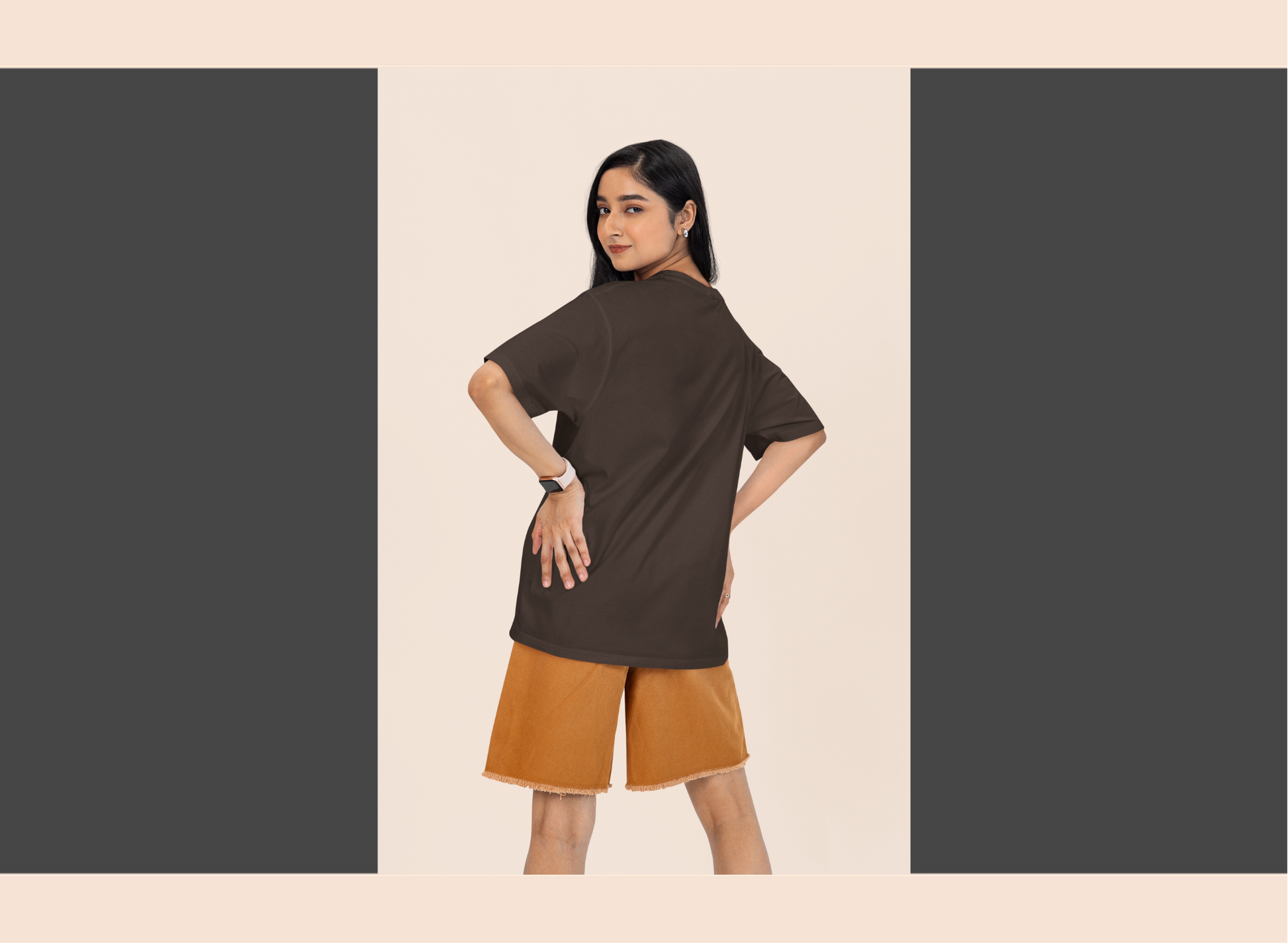 Woman wearing a brown top and orange shorts on a beige background