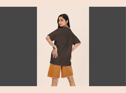 Woman wearing a brown top and orange shorts on a beige background