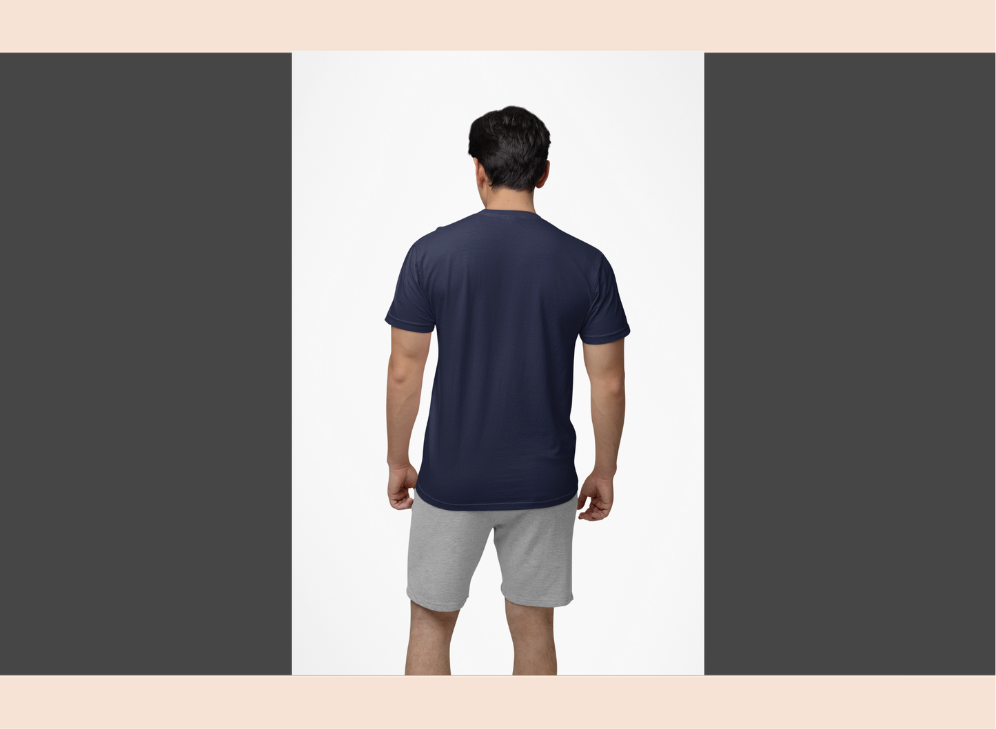 Man wearing a navy blue t-shirt and gray shorts on a white background