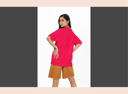 Woman wearing a bright pink top and brown shorts on a white background