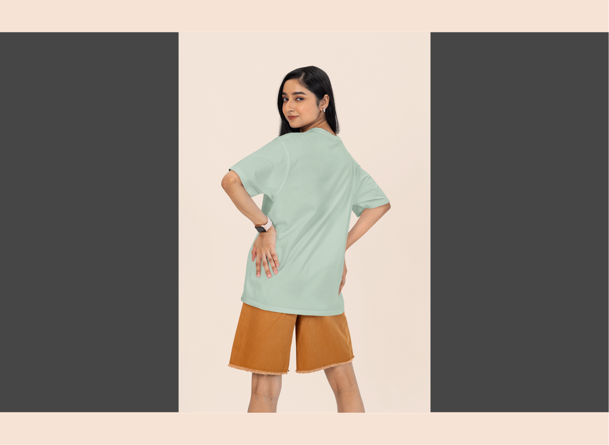 Woman wearing a light green top and brown shorts on a beige background