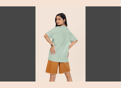 Woman wearing a light green top and brown shorts on a beige background