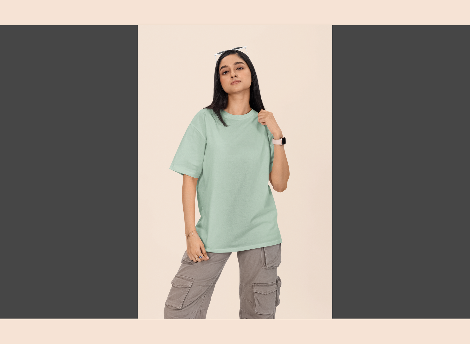 Person wearing a light green t-shirt and gray cargo pants on a beige background