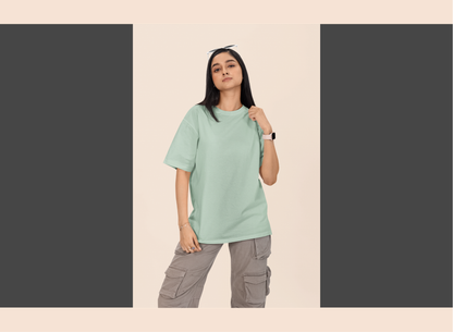 Person wearing a light green t-shirt and gray cargo pants on a beige background
