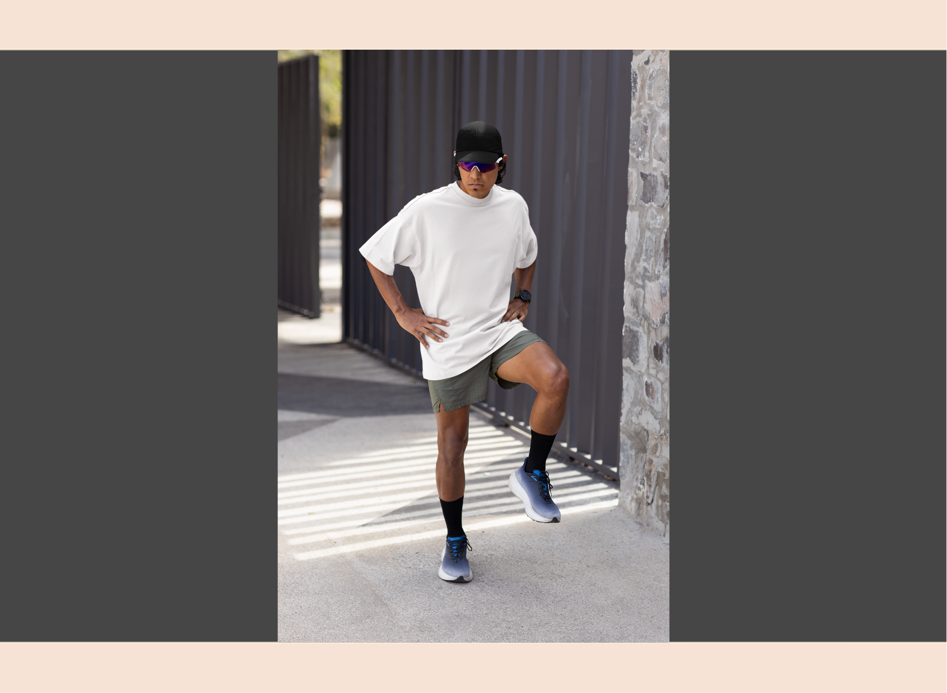 Person in athletic wear posing outdoors near a stone wall.