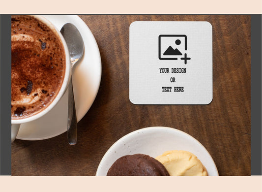Personalized coaster with customizable text or image area on a table with a cup of coffee and dessert.