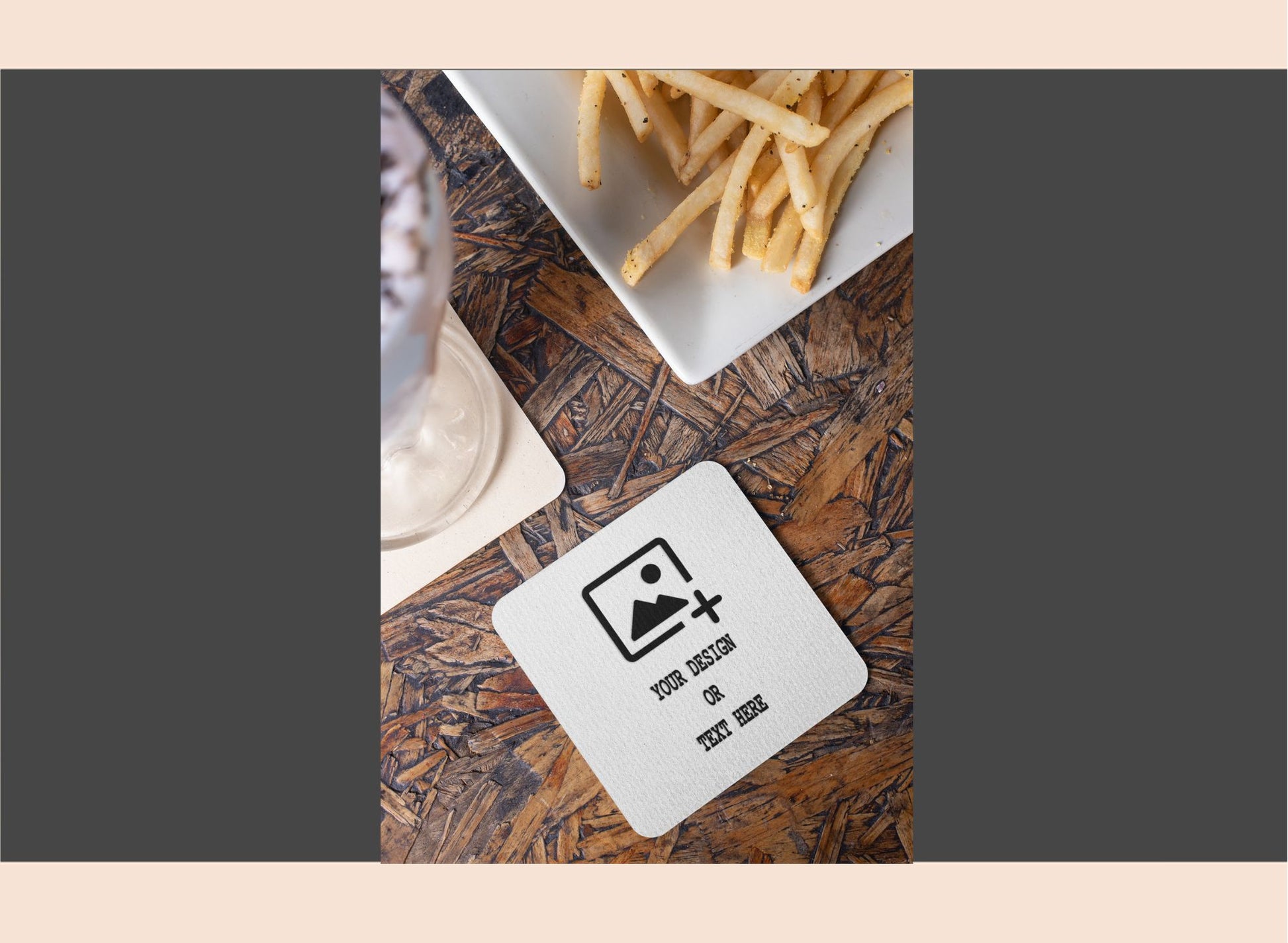 Coaster with a design on a wooden table with fries in the background