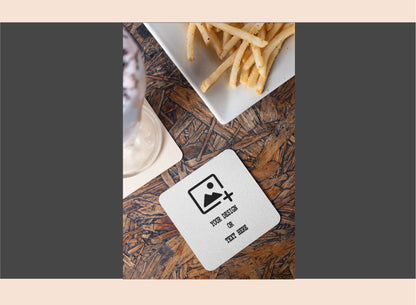 Coaster with a design on a wooden table with fries in the background