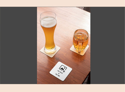 Two glasses of beer on a wooden table with coasters.