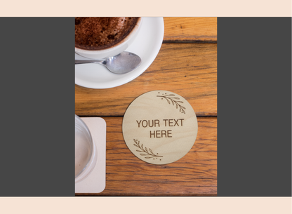 Round wooden coaster with engraved text on a wooden table with a cup of coffee.