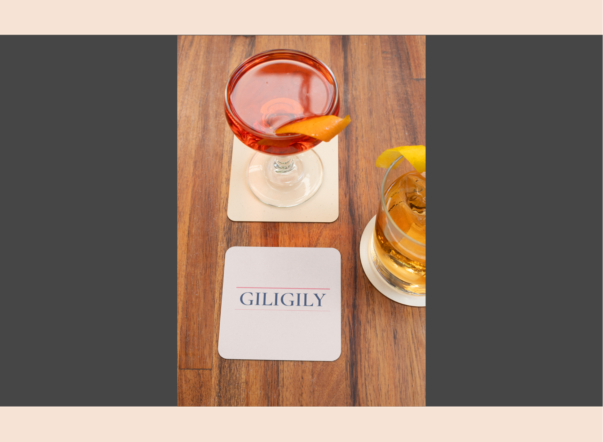 Two cocktails on a wooden table with 'GILIGILY' coasters.