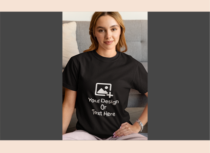 Person wearing a black t-shirt with customizable design area, sitting on a couch.