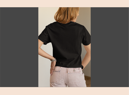 Person wearing a black t-shirt and light-colored pants in a neutral setting