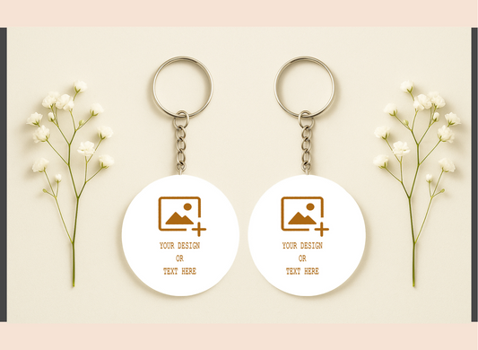 Two white keychains with customizable design or text on a light pink background with baby's breath flowers.