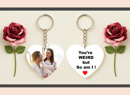 Heart-shaped keychain with a photo of a couple and text 'You're WEIRD but So am I!' between two red roses.