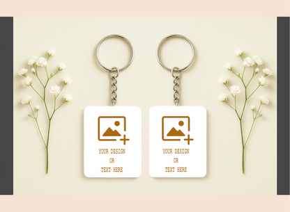 Two keychains with customizable designs on a light background with flowers.