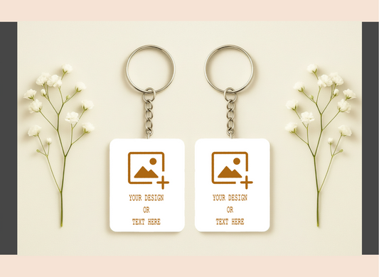 Two keychains with customizable designs on a light background with flowers.